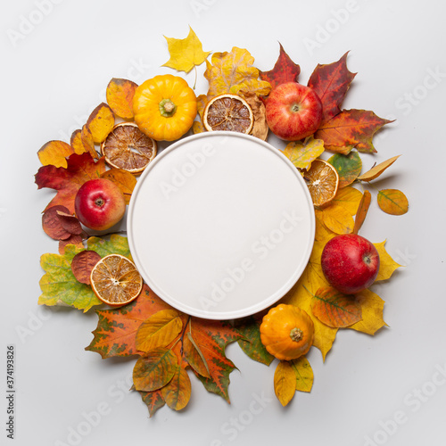 Fall harvest of apple and colorful leaves and black plate in the center with space. Top view.
