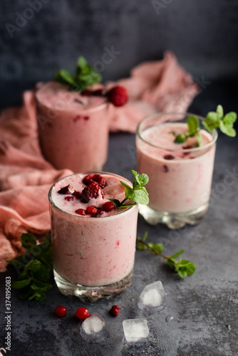 Glasses of berry smoothie on dark background.