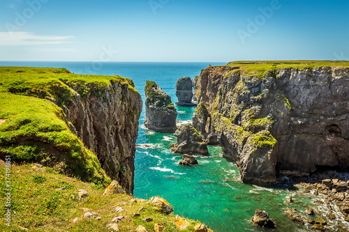 A view of rock stacks offshore from the top of a secluded cove along the Pembrokeshire coast, Wales in summer