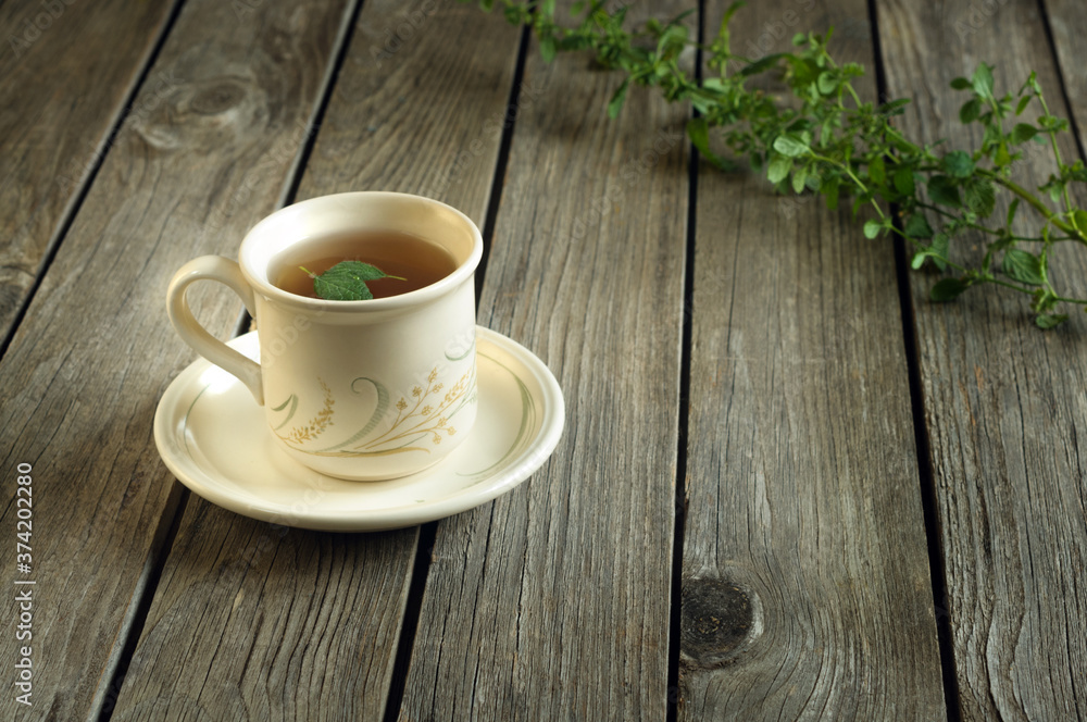 Mint tea in a mug on a table made of wooden boards. Rustic vintage style. Copy space for text. Selective focus Mint tea in a mug on a table made of wooden boards. Rustic vintage style. Copy space for text. Selective focus