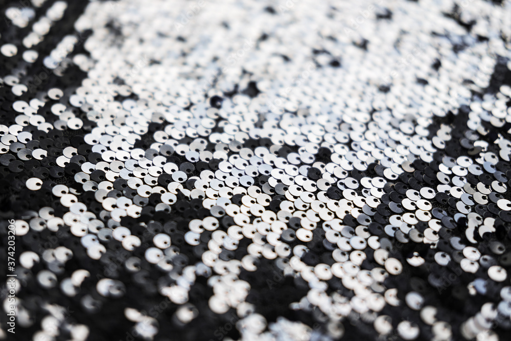 Sequin fabric texture. Shiny silver sparkling background. Clothing piece of glitter metallic for a glamorous party, celebration. Close-up. Sequin fabric texture. Shiny silver sparkling background. Clothing piece of glitter metallic for a glamorous party, celebration. Close-up.