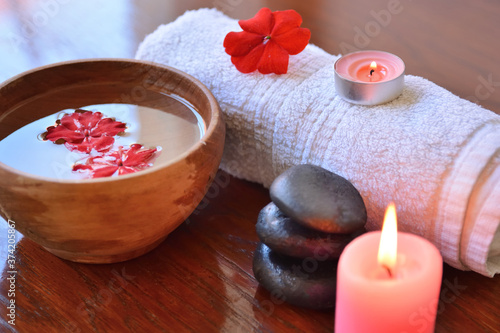 Spa and beauty salon background scene with a towel  wooden bowl  candle  and stone indoor on wooden desk. Wellness and health care concept. Close up  selective focus