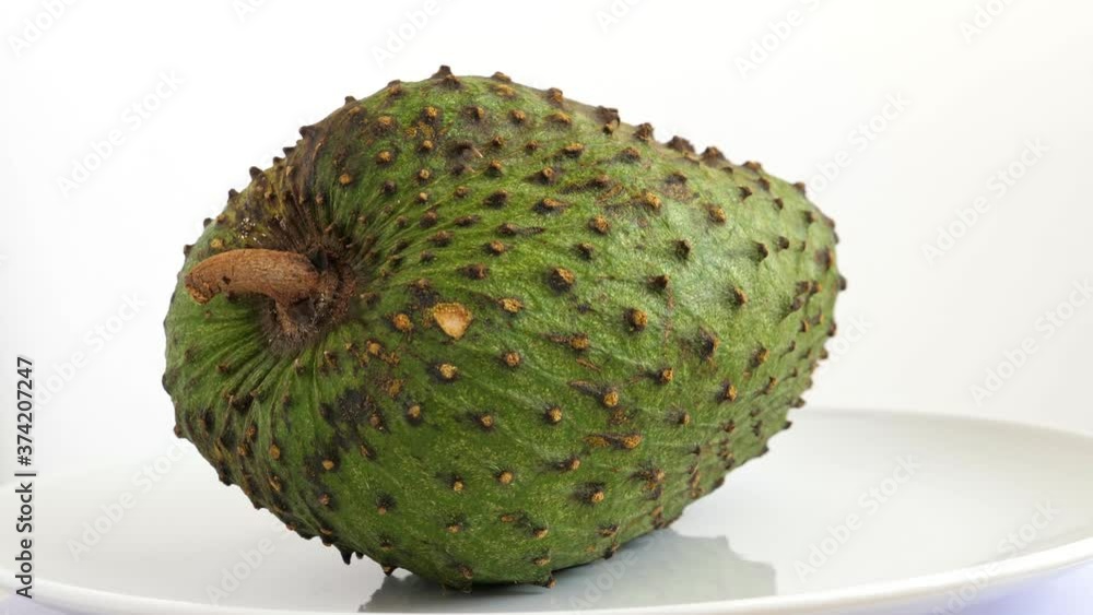 One soursop graviola, exotic, tropical fruit Guanabana on plate, Rotate. Food background One soursop graviola, exotic, tropical fruit Guanabana on plate, Rotate. Food background