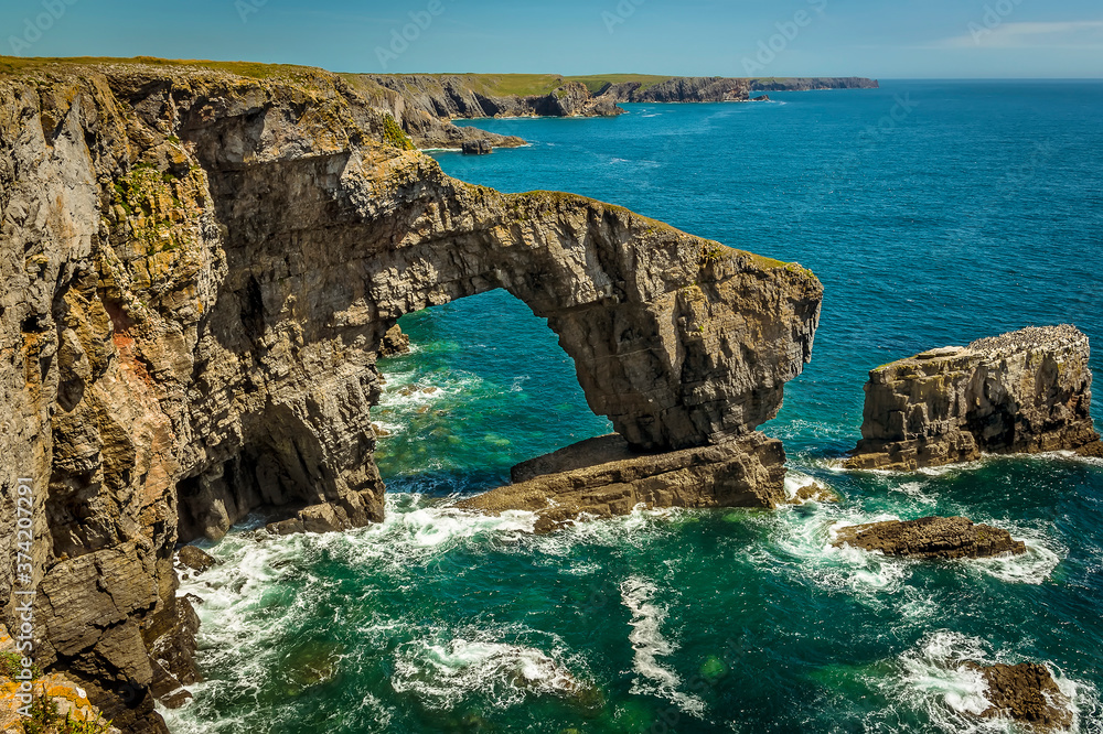 The impressive natural arch made from Carboniferous Limestone, know as the Green Bridge of Wales on the Pembrokeshire coast, near Castlemartin in early summer