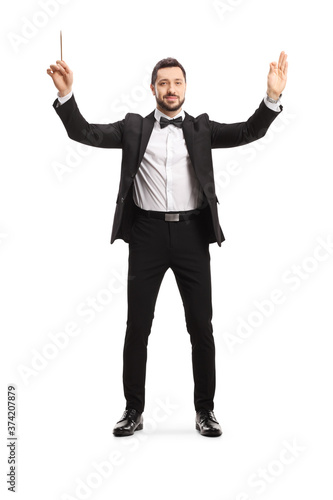 Full length portrait of a male musical conductor starting a show