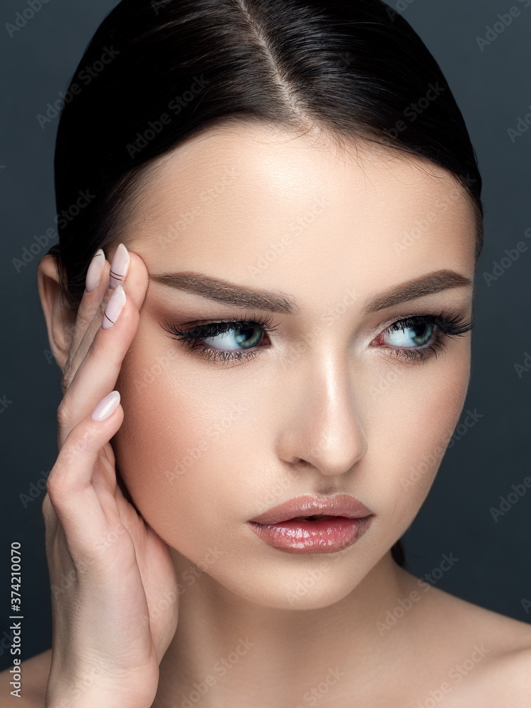 Young beautiful woman touching her face Young beautiful woman touching her face