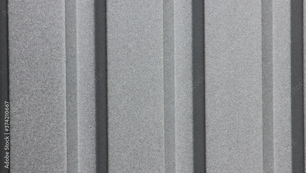 Fototapeta premium The textured background surface of the corrugated metallic grey color
