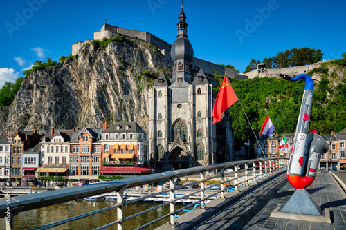 Picturesque Dinant town, Dinant Citadel and Collegiate Church of Notre Dame de Dinant and Charles de Gaulle bridge with saxophones as Dinant is hometown of saxophone inventor and flags. Namur, Blegium photo