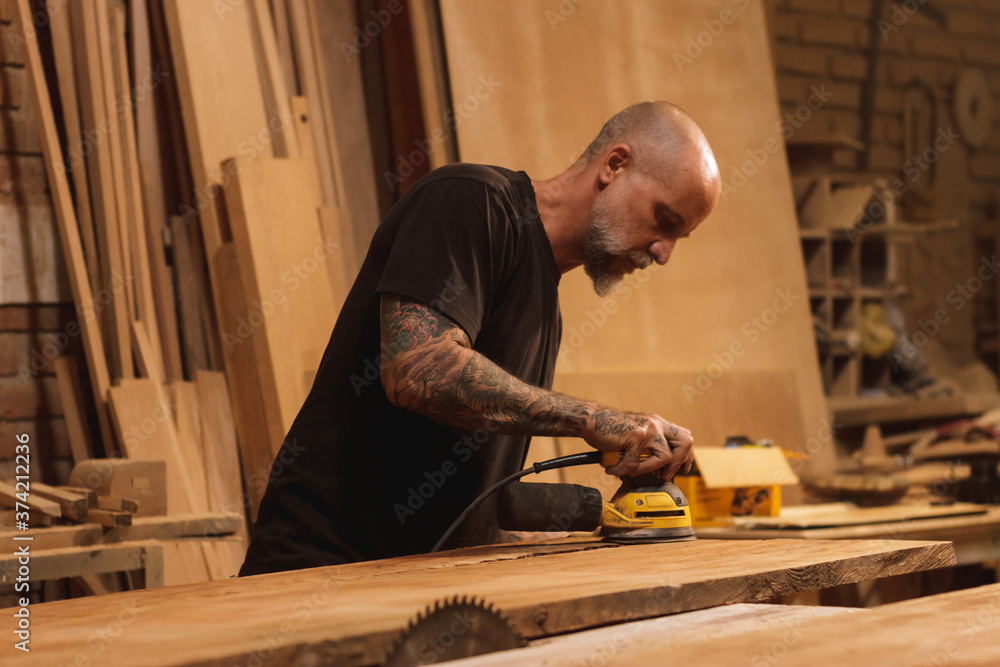 Carpintero Mexicano lijando una puerta en taller de carpintería Carpintero Mexicano lijando una puerta en taller de carpintería