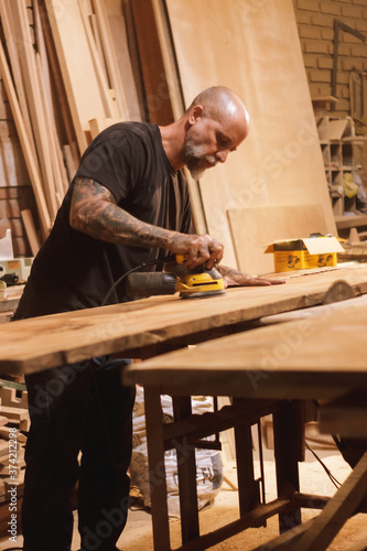 Carpintero Mexicano lijando una puerta en taller de carpintería