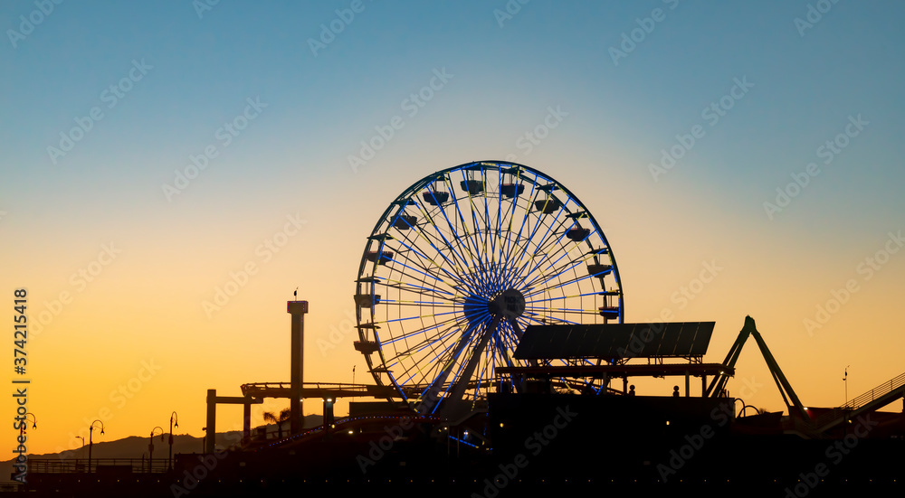 Ferris wheel at sunset in Santa Monica pier with illumination
