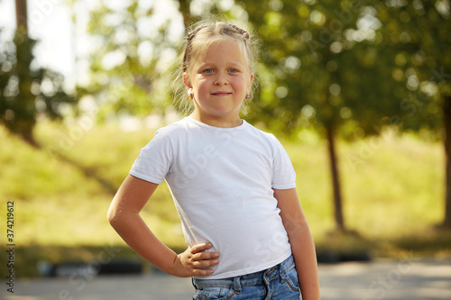 Portrait of a little girl in a white t-shirt in the Park Sunny day