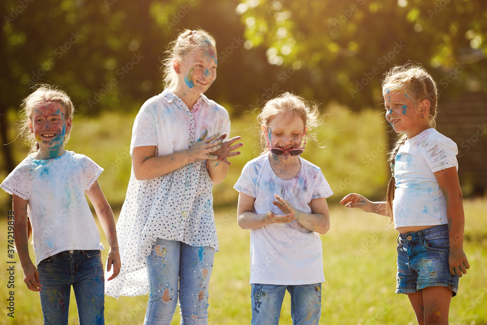 Fototapeta premium Friends having fun with powder paint on a sunny day. Selective focus