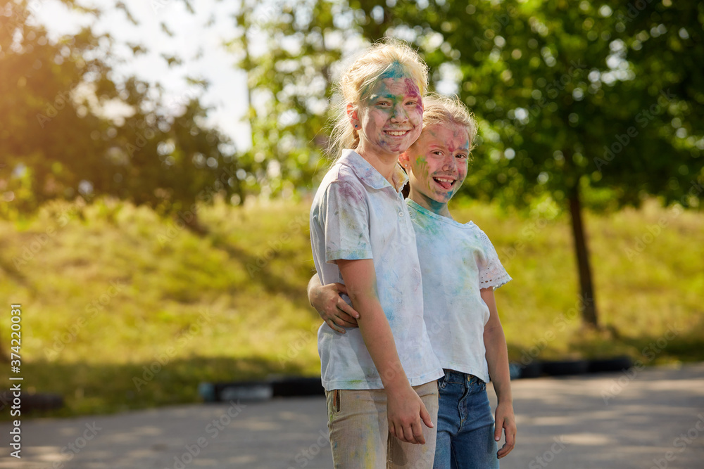 Obraz premium Two sisters pose for the camera outdoors in a Sunny Park. Selective focus