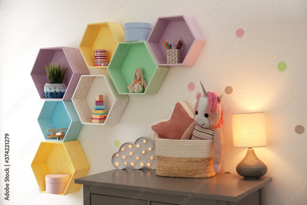 Bright colorful shelves on light wall in room. Interior design Bright colorful shelves on light wall in room. Interior design