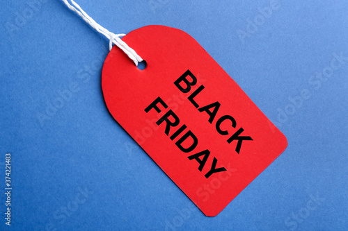 Red blank tag on blue background, top view. Black Friday concept