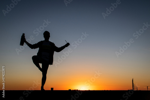 Fototapeta Naklejka Na Ścianę i Meble -  silhouette of a man on a pier at sunset