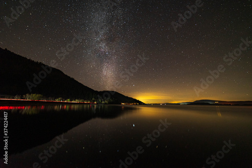Bassenthwaite Lake in the lake district with the Milky Way and car lights trailing from the A66 on the lake