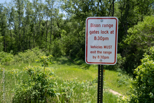 Sign - Bison range gates lock, vehicles must exit in the evening - at Minneopa State Park in Mankato Minnesota photo