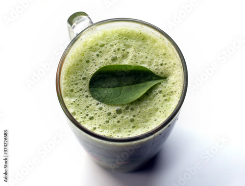 a glass of green cocktail with spinage leaf photo