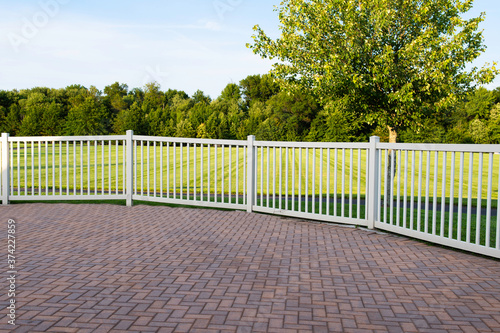 grey and brown paving stone and white vinyl fence