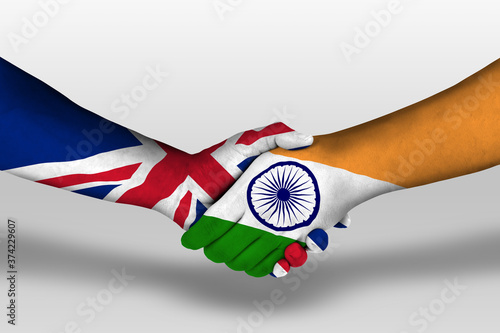 Handshake between india and united kingdom flags painted on hands, illustration with clipping path. photo