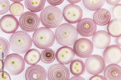 Onions background. Sliced onion cuts. Backlit photography. Light passes through the elements. Combination of colors and shapes that produce reactions in taste. 