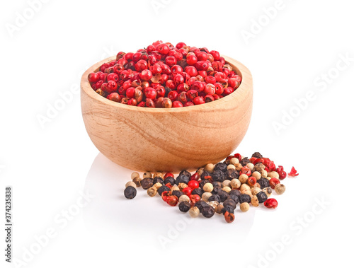 Obraz na płótnie dried pink peppers in wood bowl isolated on white background. w salonie