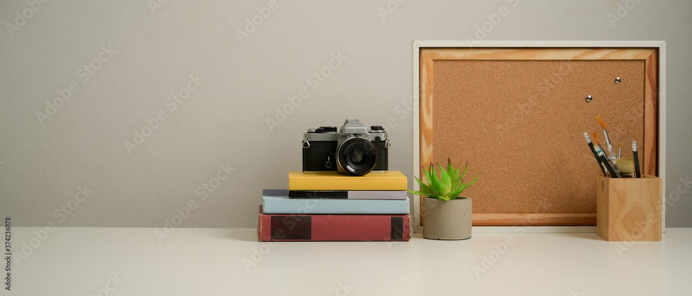 Workplace with copy space, books, camera, stationery and decorations in home office Workplace with copy space, books, camera, stationery and decorations in home office