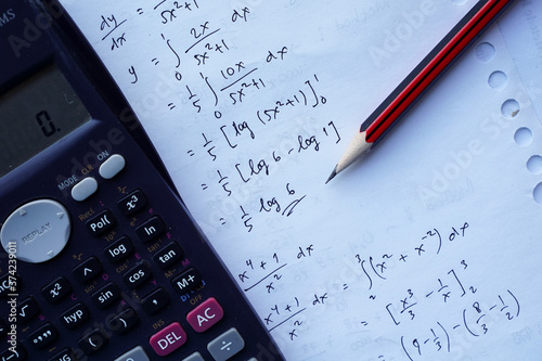 scientific math workout. sheet paper with solving equation math next to calculator