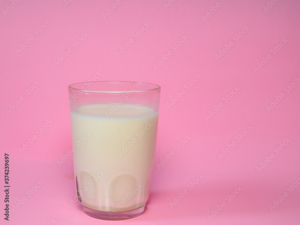 A glass of milk isolated on pink background. Fresh milk
