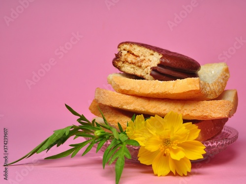 Dry rusk bread and choco pie chocolate on pink background. Healhty breakfast menu