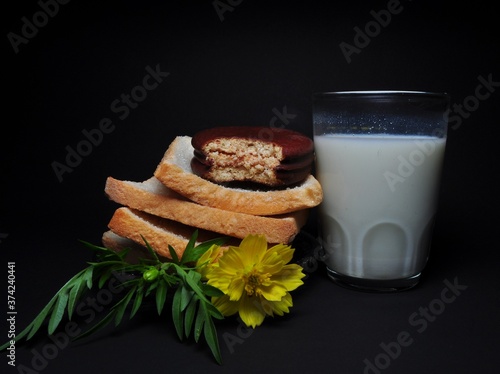 Dry rusk bread and a glass of milk isolated on black background. Healhty breakfast menu