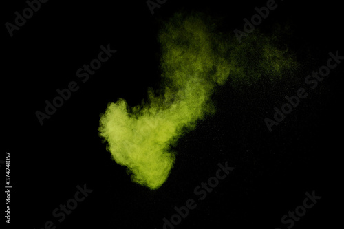 Light green powder explosion on black background. Colored powder cloud. Colorful dust explode. Paint Holi.