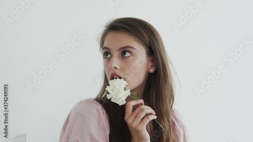 Attractive beautiful young woman model with flowers looking and posing at camera