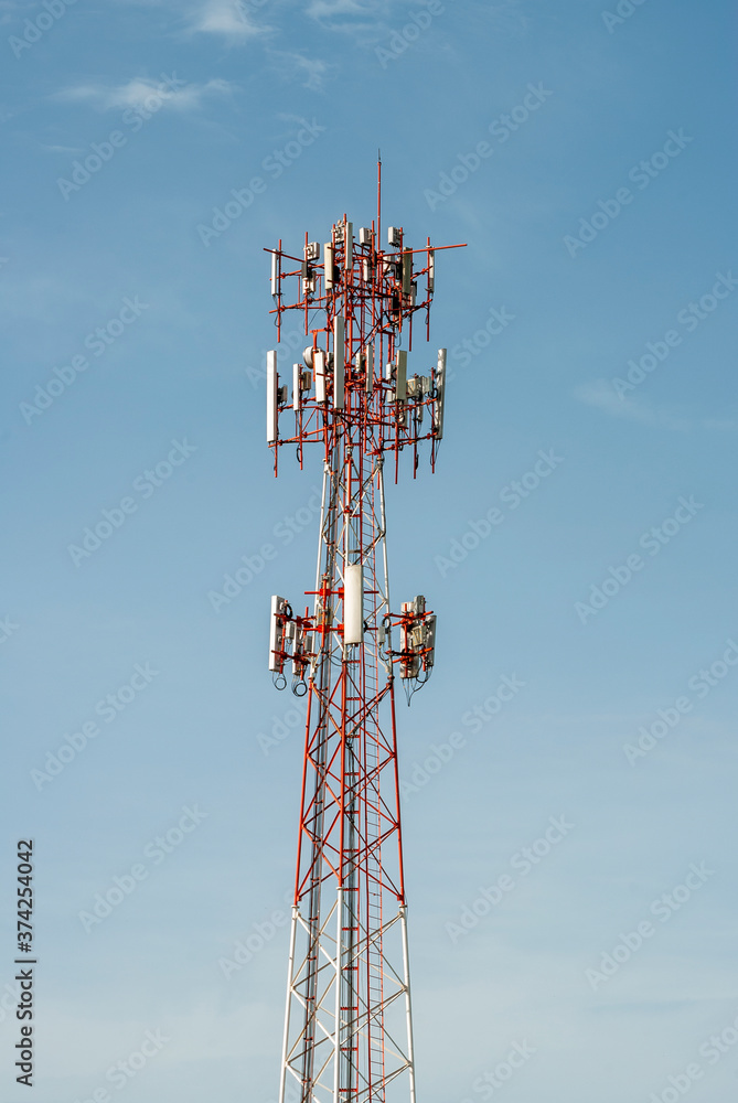 Telecommunication tower illuminated with natural light outdoors with blue sky.