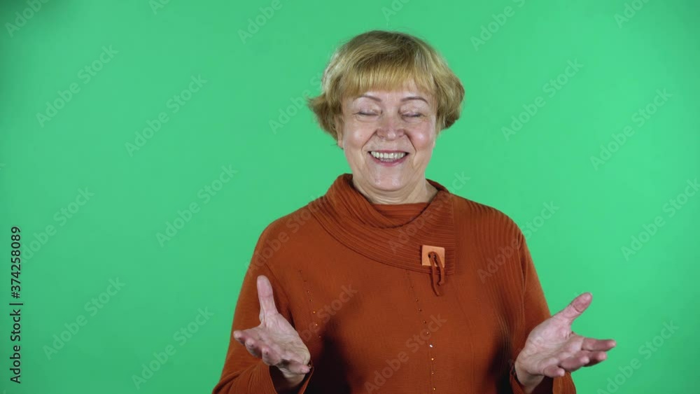Portrait of happy senior woman is friendly communicates with someone isolated over green background. Portrait of happy senior woman is friendly communicates with someone isolated over green background.