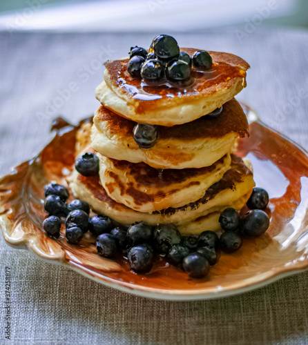 a stack of pancakes with blueberries and maple syrup