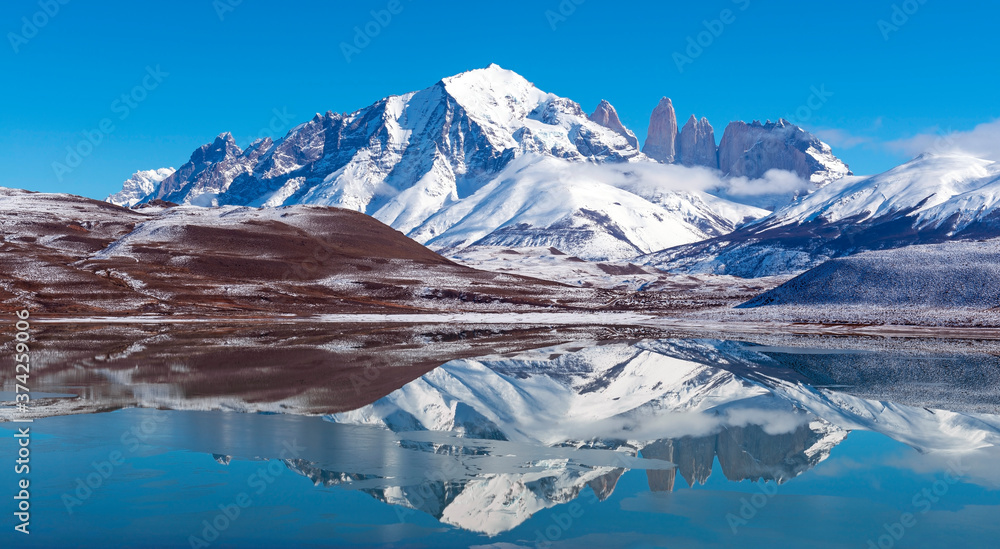 Panoramic reflection of the Torres del Paine granite peaks in winter with copy space, Torres del Paine national park, Patagonia, Chile.