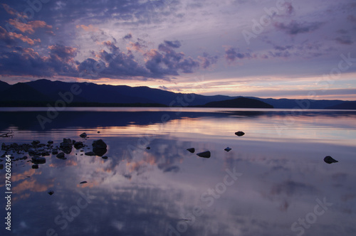                                                                    Twilight sky and silhouettes of mountains reflected on the lake of still water. Lake kussharo hokkaido japan.