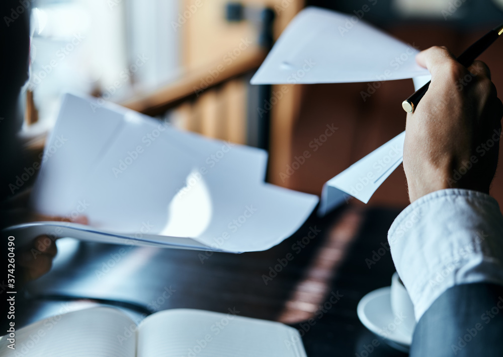 Fototapeta premium businesswoman in a cafe with a book on the table documents a cup of coffee work lifestyle