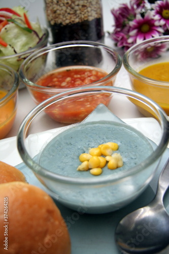 Variety of colorful vegetables cream soups and ingredients for soup with bun.