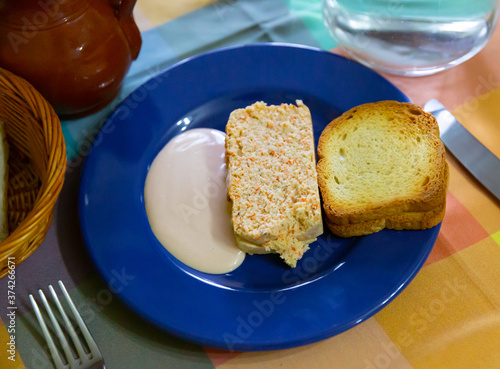 Slice of Scorpaena scrofa (red scorpionfish) cake with toasted bread and allioli. Traditional Asturian recipe.. photo