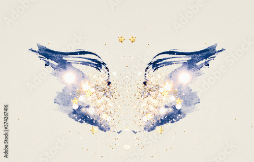 Glitter and glittering stars on abstract blue watercolor wings in vintage nostalgic colors.