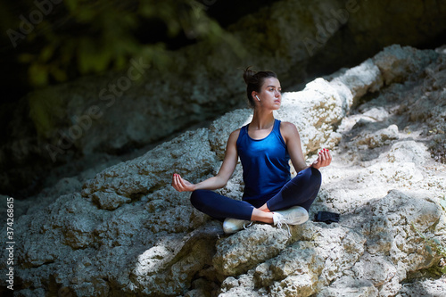 Meditation. Yoga time. Pilates. Woman meditates on fresh air. Lady wearing comfy sportswear. Sharp hill. Copy space
