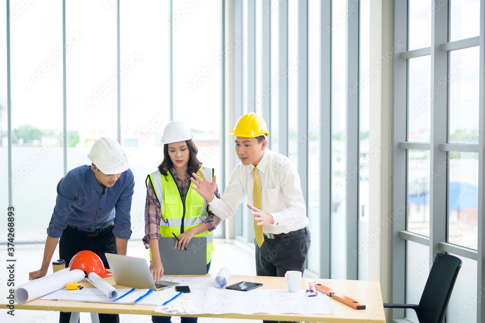 Engineering people are analytics construction plans with blueprint in office Engineering people are analytics construction plans with blueprint in office