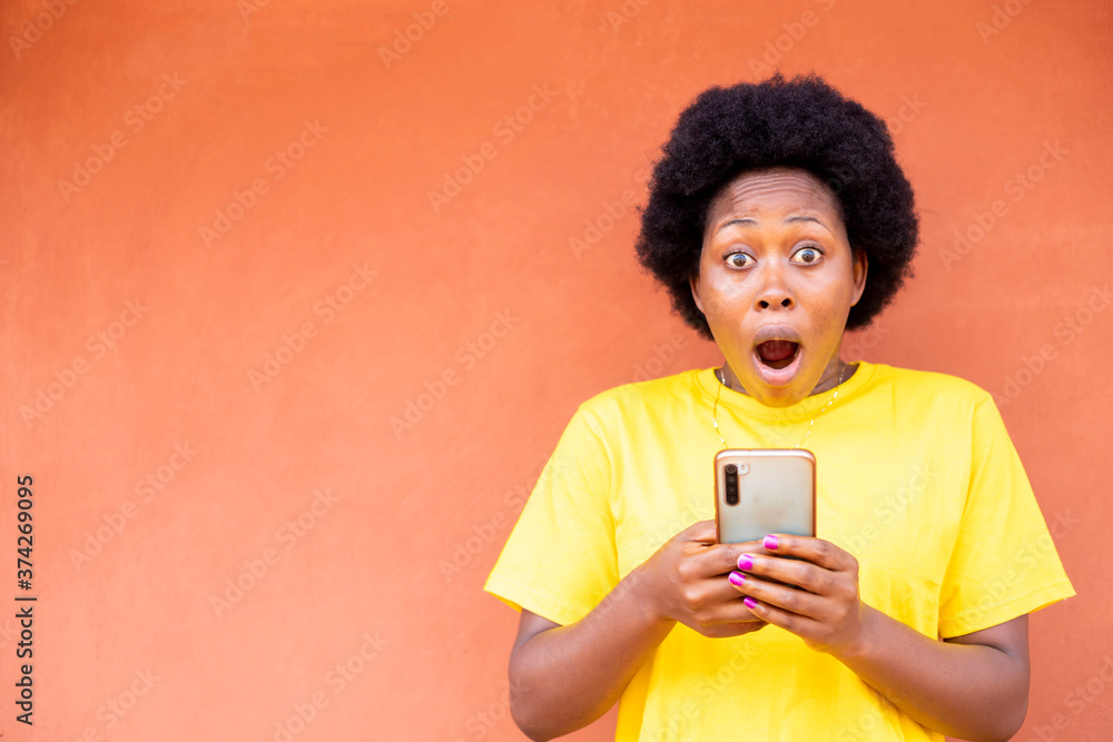 excited black african young woman using mobile phone excited black african young woman using mobile phone