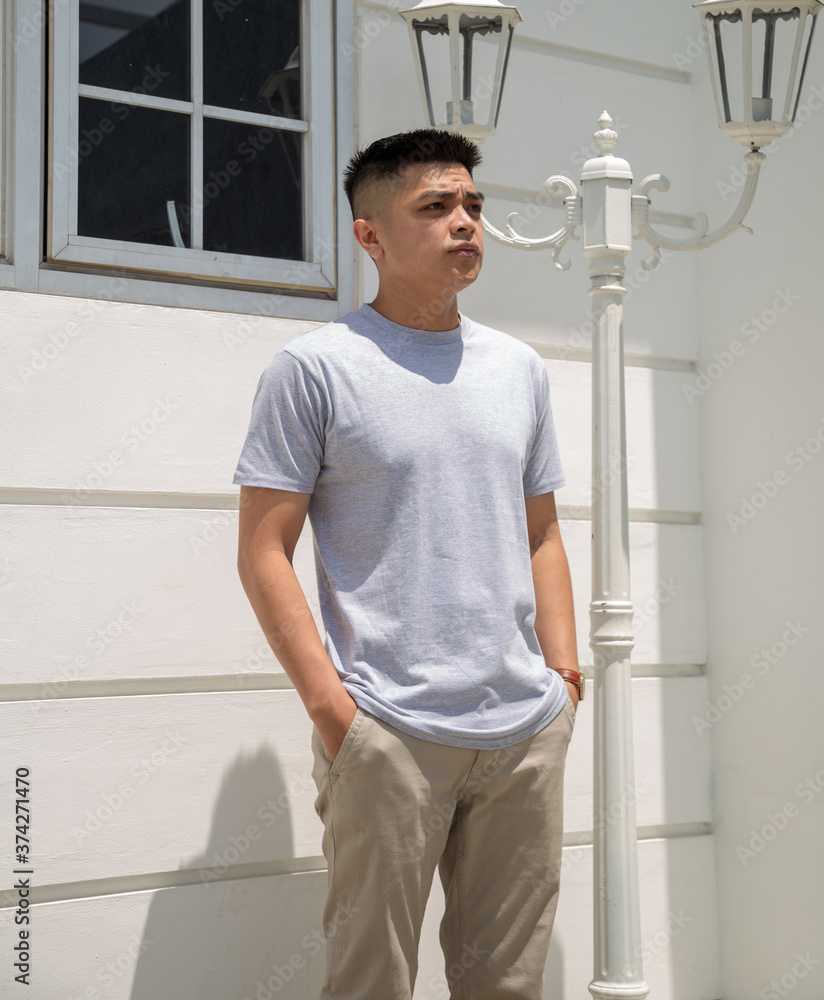Fototapeta premium Young handsome man wearing heather grey t shirt short sleeve was posing at outdoor