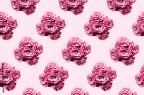 Pattern made from bouquets of rose flowers on a pink pastel background. Monochrome creative concept.