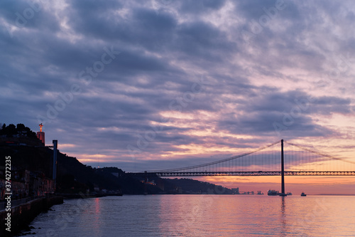 Sunset on Tagus river in Lisbon. View on Bridge and Statue of Jesus Christ. © luengo_ua